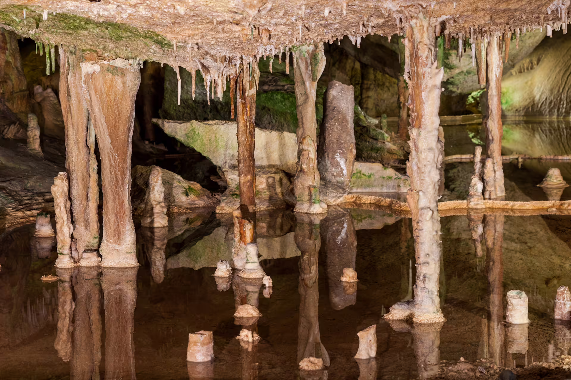 Stalactites and stalagmites reflected in underground lake on Can Marçá Cave guided tour, Ibiza entry included