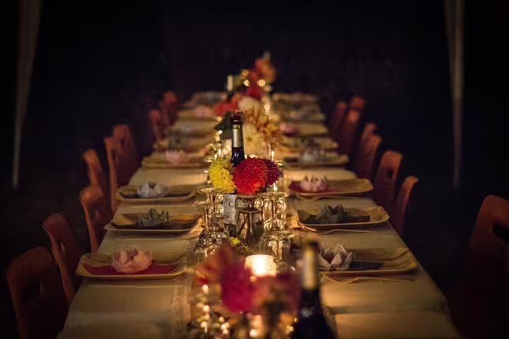 Candlelit dining table set for Sharm El Sheikh dinner cruise boat tour with flowers, glassware and place settings