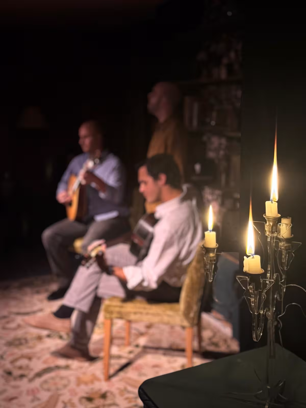 Candlelit Fado show featuring talented musicians playing guitars, capturing the soulful essence of Portuguese culture.