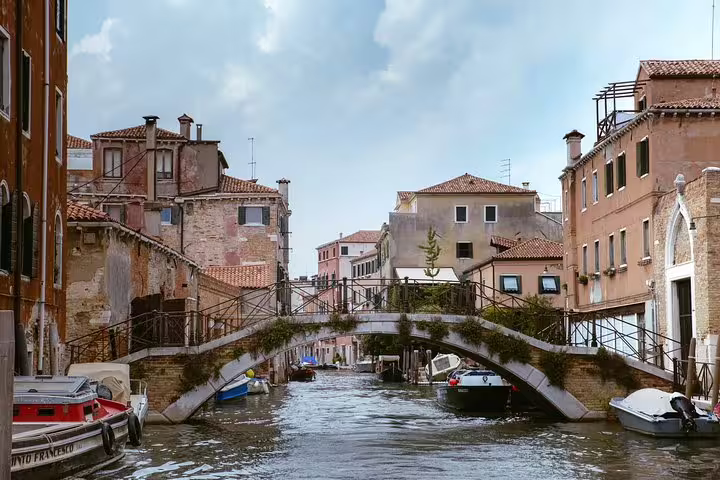 Charming canal view in Cannaregio district featuring a rustic bridge and traditional Venetian buildings.