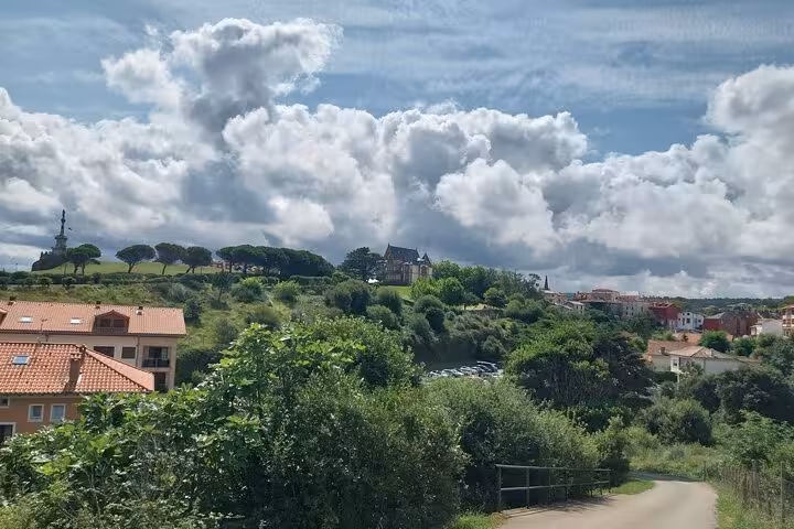 Scenic view of Cantabria's lush landscape under a dramatic cloudy sky during a full-day coastal tour.