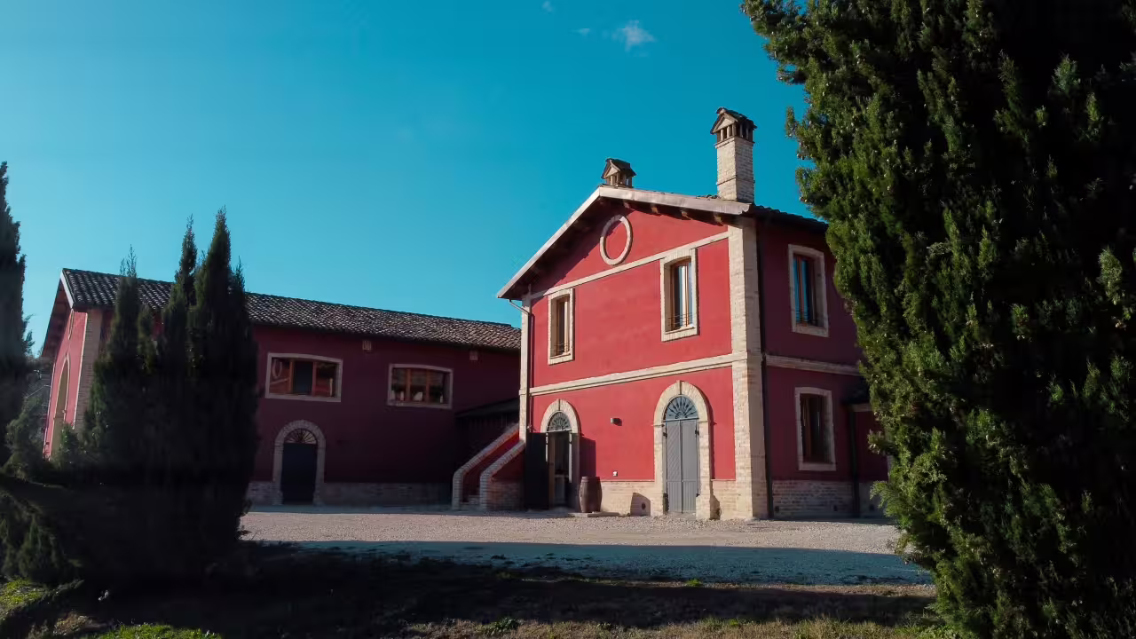 Red farmhouse at Cantina D'Erasmo in Marche, Italy, meeting point for guided winery tour and tastings