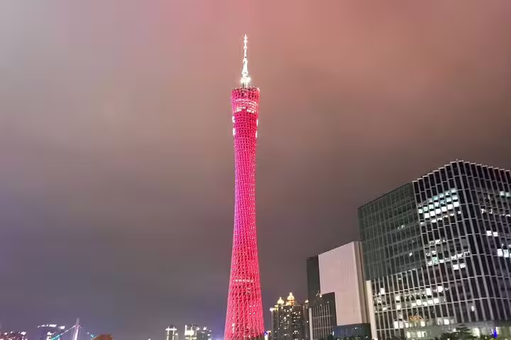 Stunning view of the illuminated Canton Tower glowing red against the night sky in Guangzhou, perfect for a Pearl River cruise.