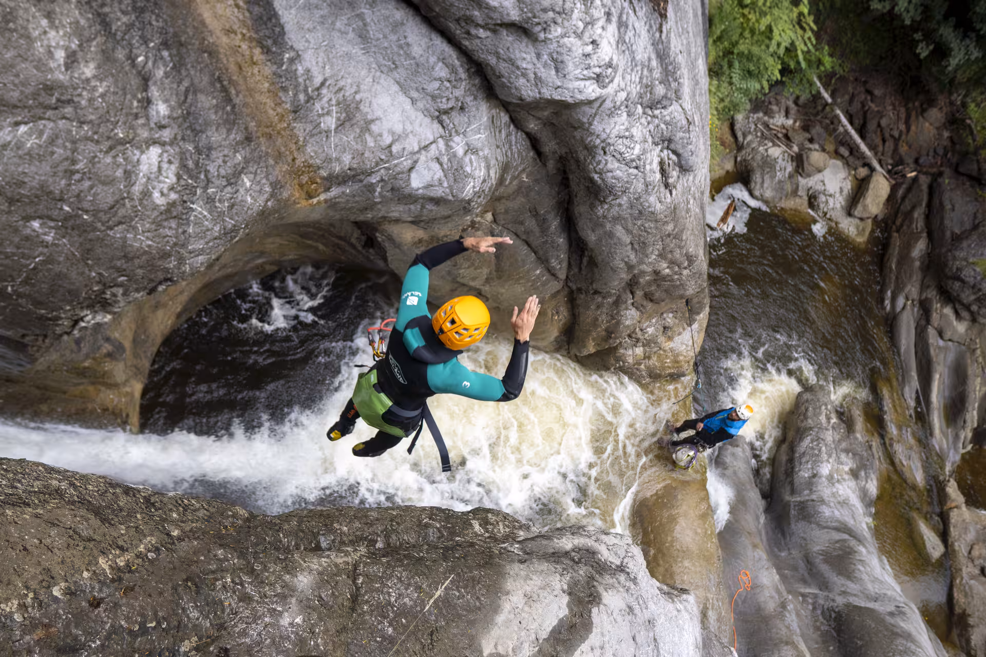 Adventurer leaps into Chli Schliere canyon waters near Luzern, showcasing thrilling canyoning experience.