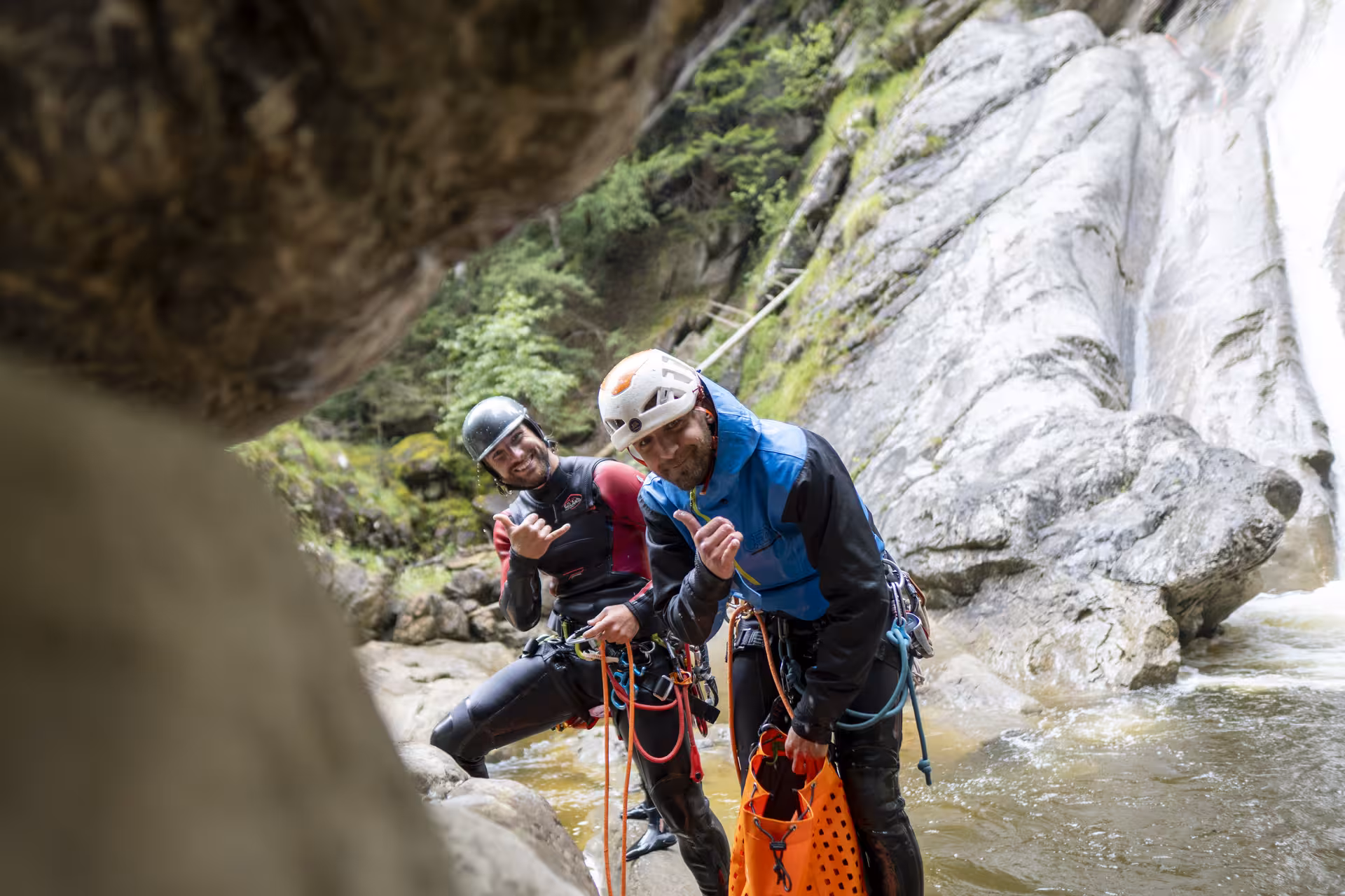Two canyoning guides give thumbs up in Chli Schliere, highlighting exciting adventure tours near Luzern.