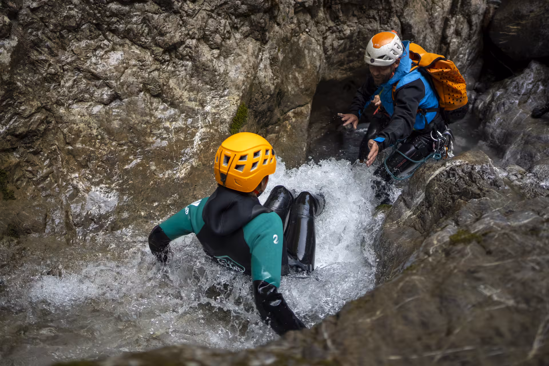 Adventurers navigate a rocky stream during an exhilarating canyoning experience in Interlaken, Switzerland.