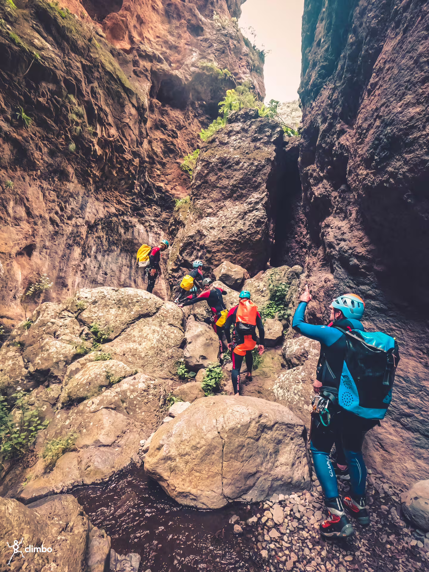 Group of canyoners hiking through a rocky gorge, highlighting the rugged landscape of rainforest canyoning tours.