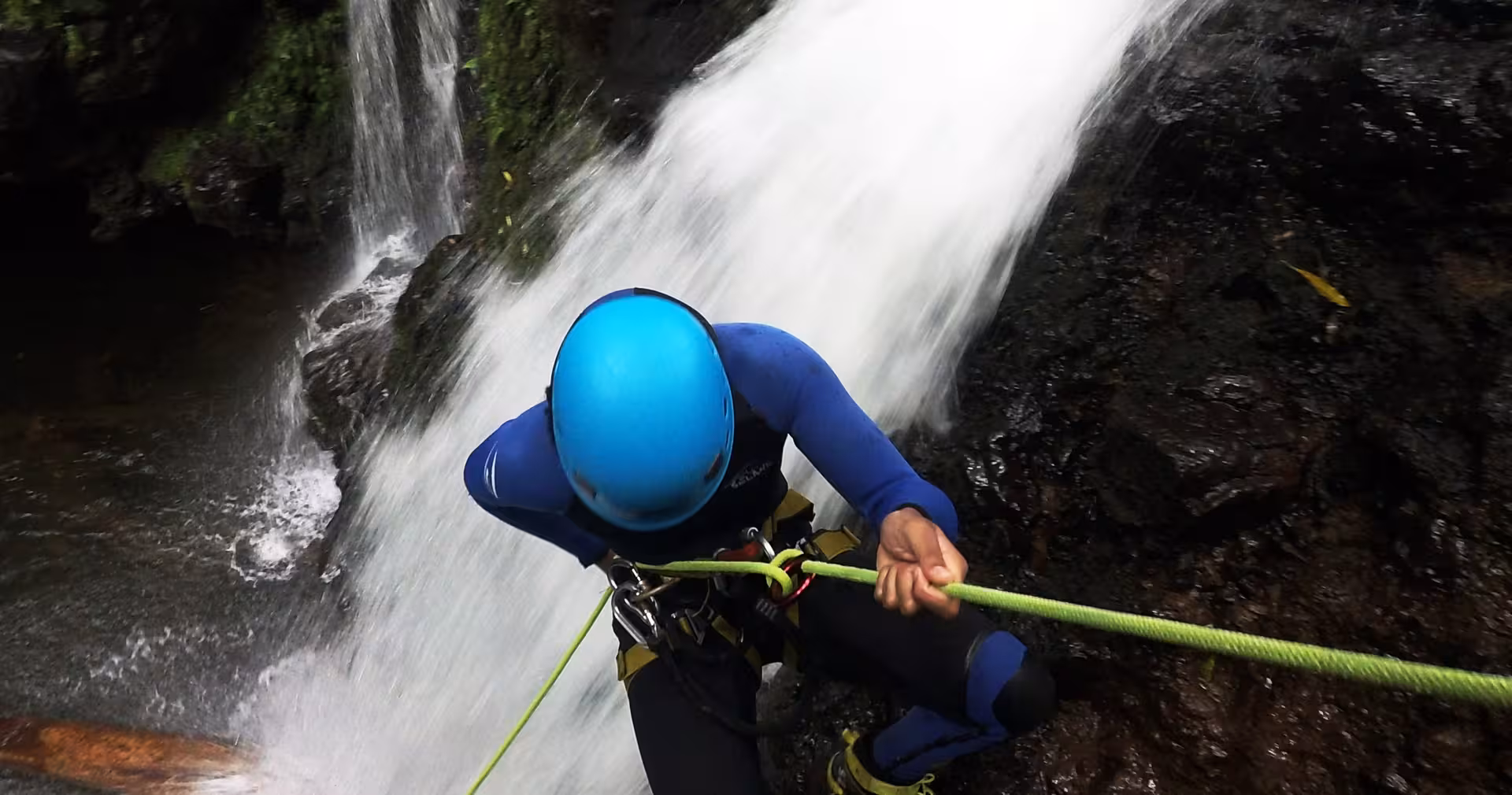 Canyoning rappel beside a waterfall in Ribeira dos Caldeirões, São Miguel, half-day adventure with transport