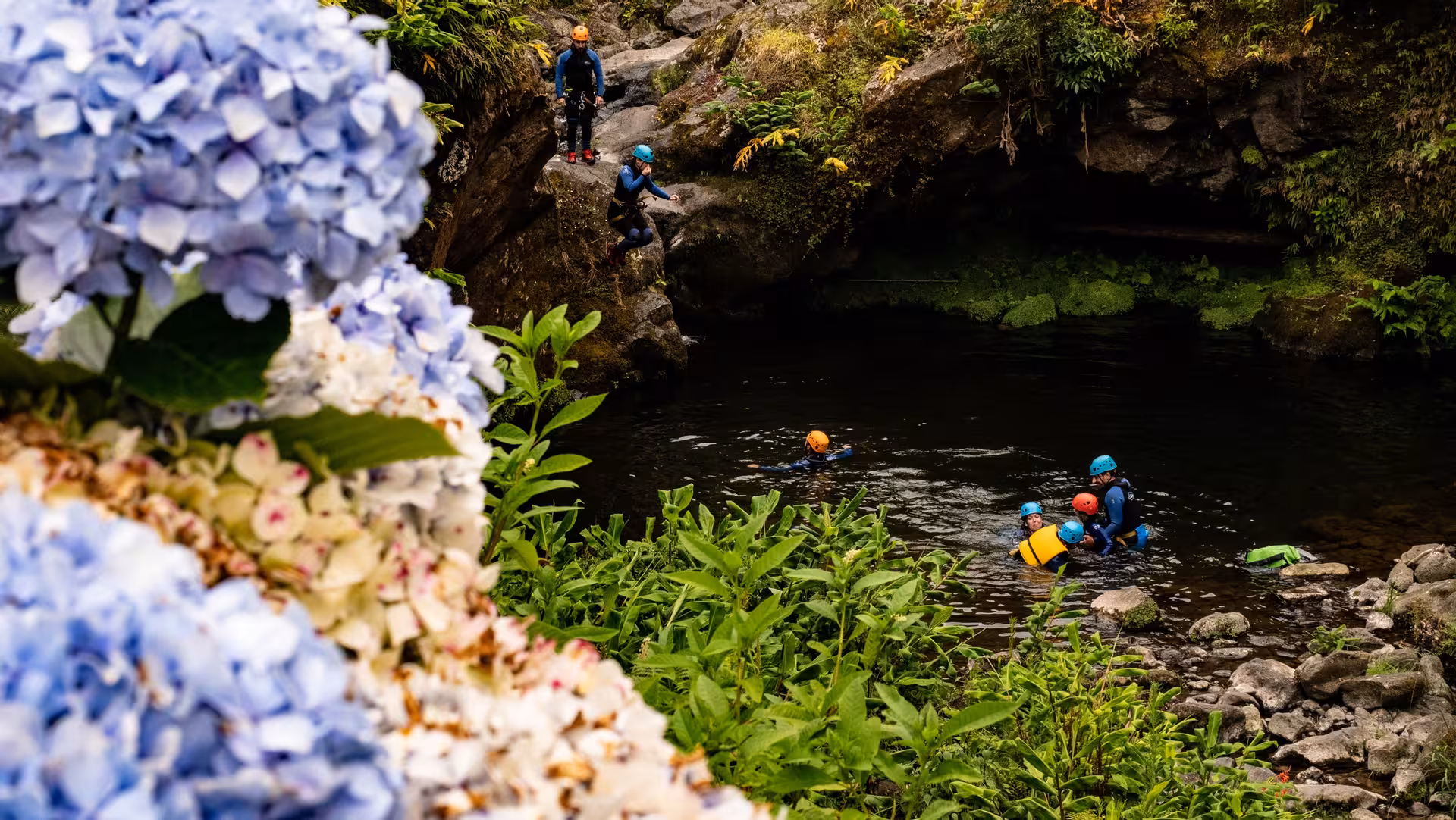 Group canyoning in Ribeira dos Caldeirões, São Miguel, swimming in a natural pool on a half-day tour