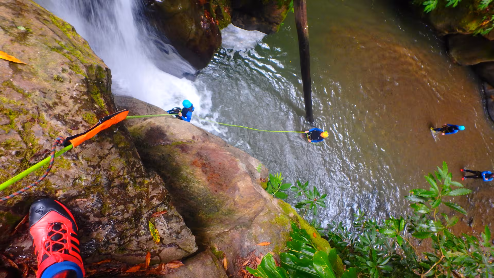Top view of canyoning rope rappel into a pool by Salto do Cabrito waterfall, Azores half-day adventure
