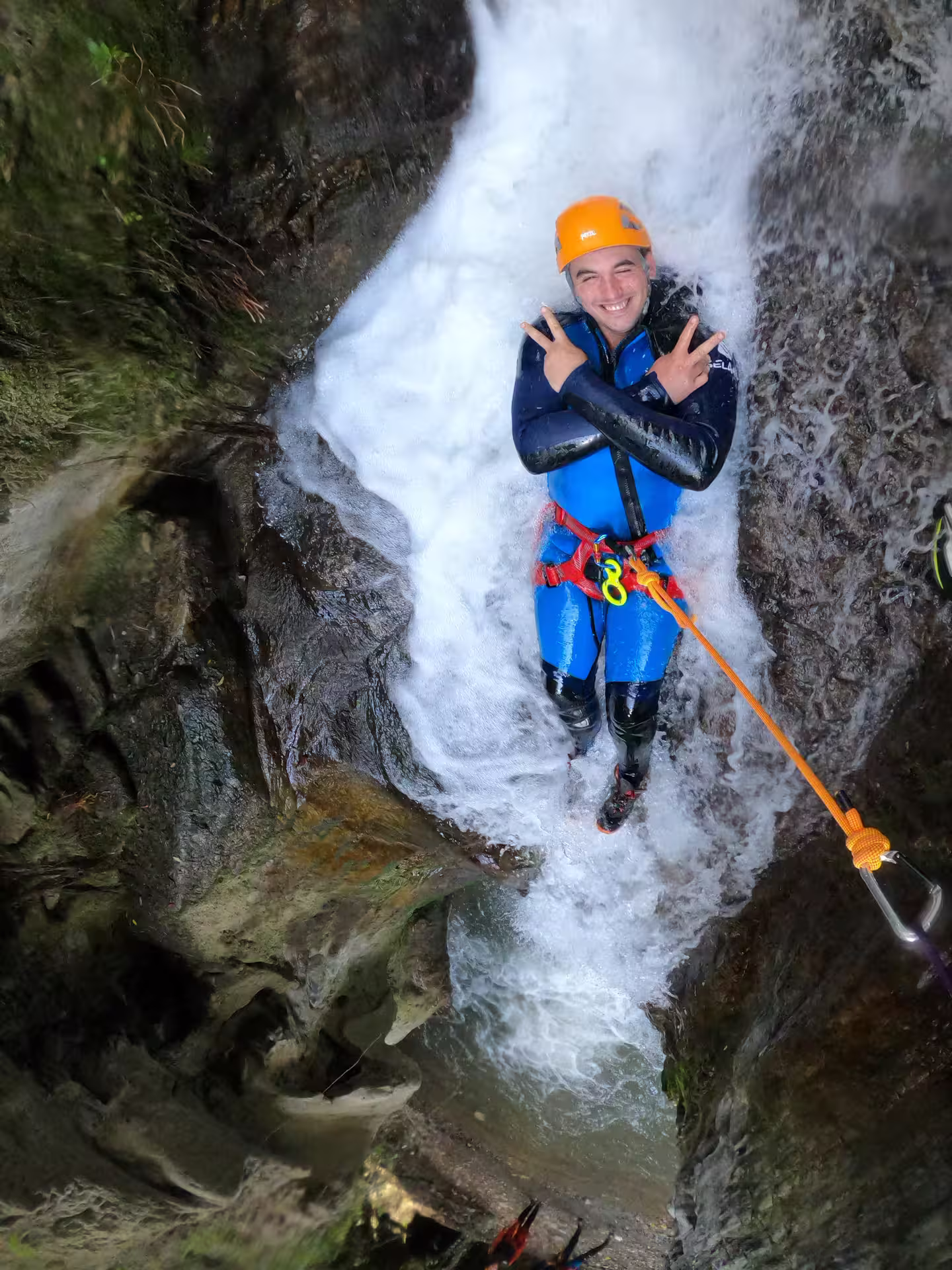 Adventurer in wetsuit and helmet enjoying a thrilling canyoning experience at Sima del Diablo near Estepona.