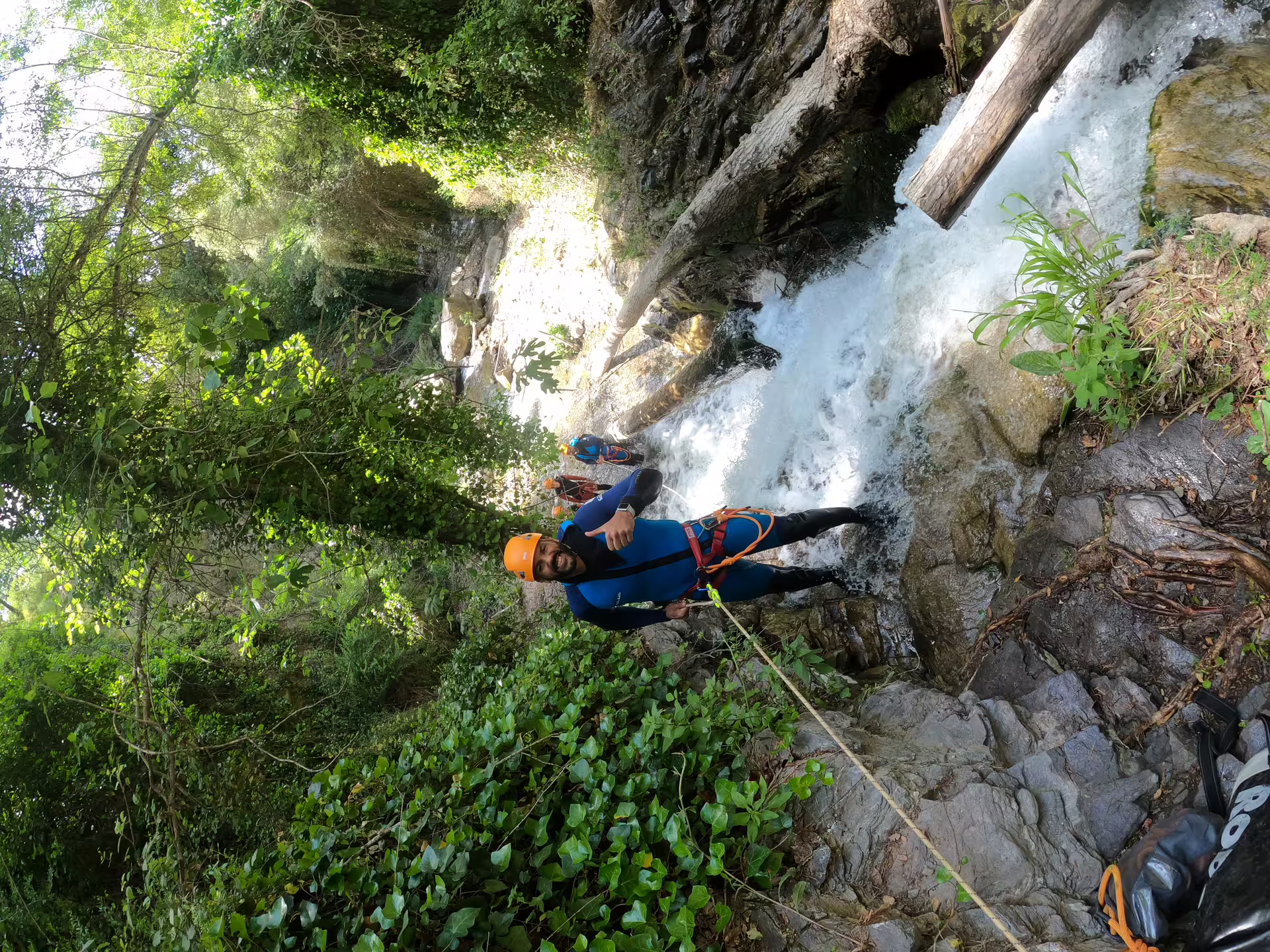 Adventurer canyoning through lush greenery and waterfalls at Sima del Diablo near Estepona, perfect for thrill-seekers.