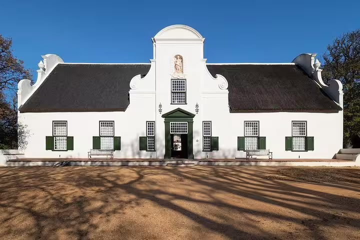 Elegant Cape Dutch architecture at a historic Constantia wine estate, ideal for a private wine tasting experience.