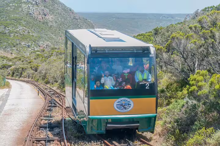Funicular carrying tourists through lush landscape at Cape of Good Hope, a highlight of small group tours.
