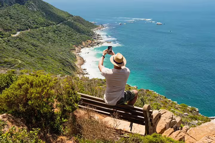 Traveler capturing stunning coastal views at Cape of Good Hope, highlighting breathtaking scenery on a small group tour.
