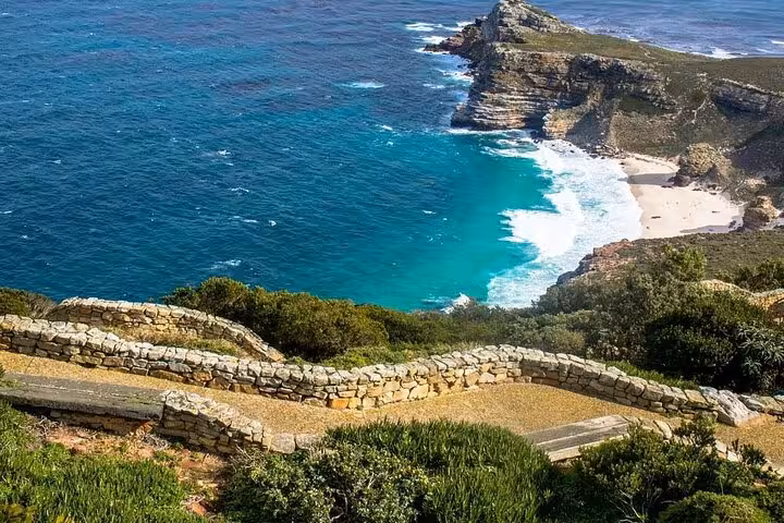 Panoramic view of Cape Point's rugged cliffs and turquoise waters, highlighting the scenic coastal beauty of the area.