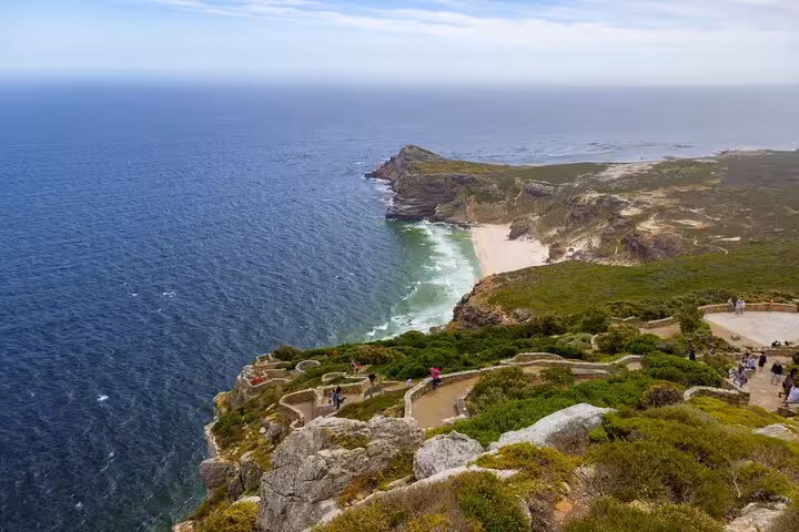 Panoramic view from Cape Point showcasing the dramatic coastline, sandy beach, and vast ocean in Cape Town.