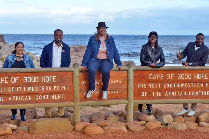 Tourists at Cape of Good Hope sign, highlighting the southernmost point of the African continent.