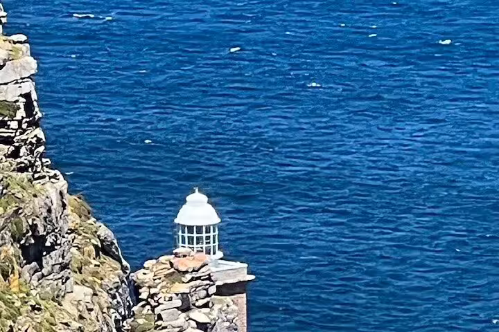 Cape Point lighthouse perched on rugged cliffs overlooking the ocean, a scenic stop on the Cape Town tour.