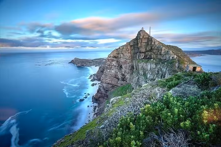 Dramatic ocean view from Cape Point with rugged cliffs and lush greenery, ideal for a South African adventure tour.