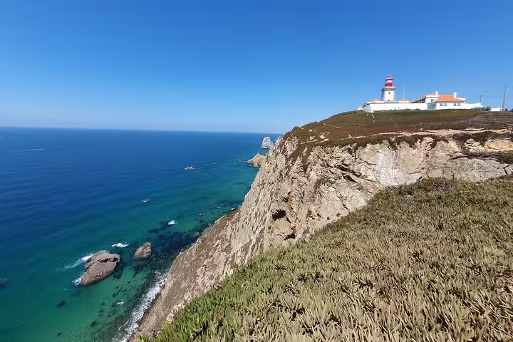 Breathtaking Cape Roca coastline with a lighthouse perched on rugged cliffs, a must-see on the Cascais tour.