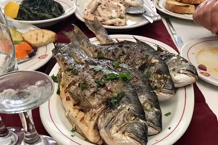 Greek seaside lunch of grilled whole fish and meze, perfect stop on Cape Sounio private tour from Athens