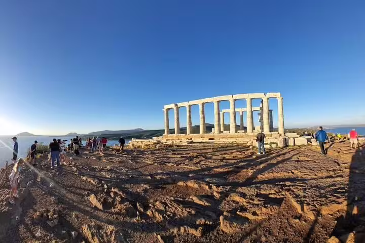 Visitors exploring the Temple of Poseidon ruins at Cape Sounio, a scenic private day trip from Athens on the coast