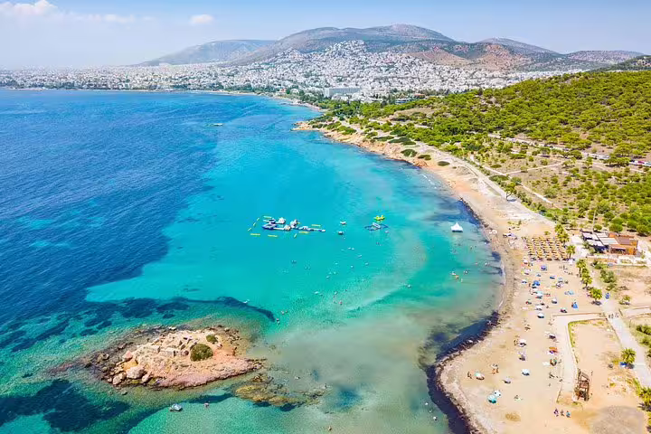 Aerial view of Cape Sounion's stunning coastline, featuring turquoise waters and sandy beaches, ideal for a full or half-day trip from Athens.