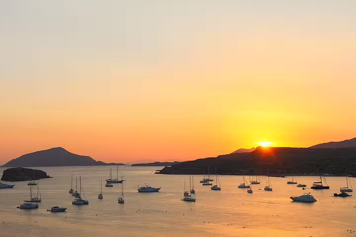 Golden sunset over Cape Sounion with boats in the Aegean Sea, ideal for scenic full-day or half-day trips from Athens.