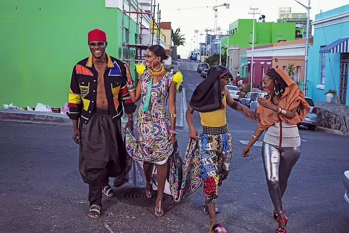 Group of stylishly dressed friends walking through the colorful streets of Cape Town's Bo-Kaap area.