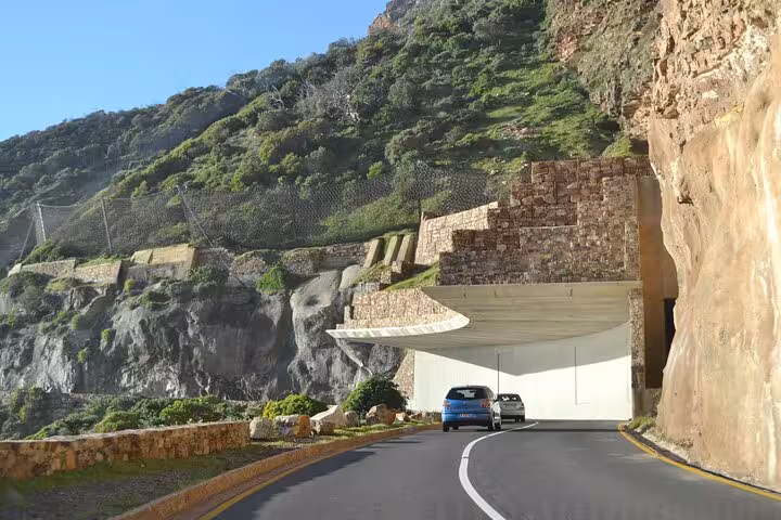 Scenic drive through a tunnel on the coastal road to Table Mountain, showcasing Cape Town's stunning landscape.
