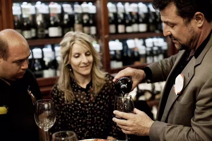 Wine expert pouring red wine for guests during a private Constantia wine tasting experience in Cape Town.