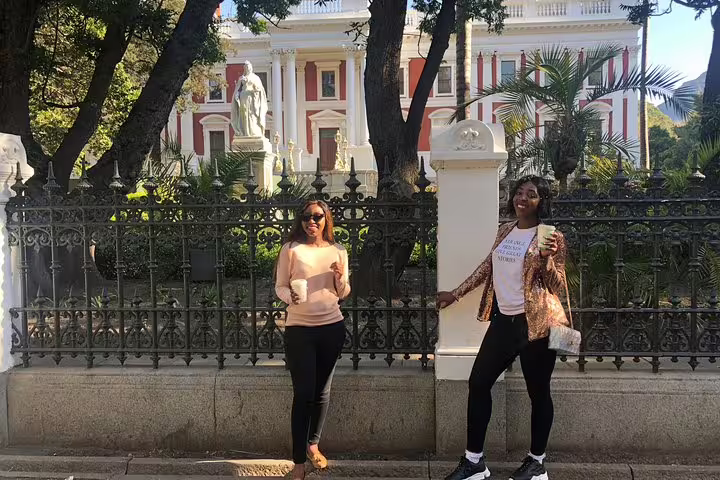Two women enjoying a sunny day outside the historic Houses of Parliament in Cape Town.