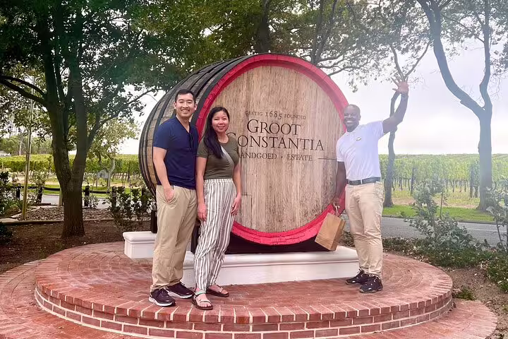 Tourists with a guide at Groot Constantia wine estate, enjoying a private tour in Cape Town's vineyards.