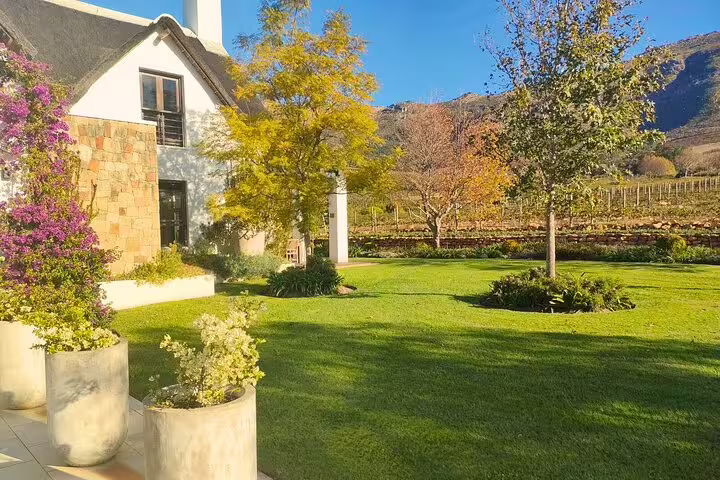 Cape Town wine tasting tour at a vineyard estate with manicured gardens, cellar building and mountain views