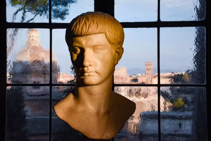 Marble bust of a Roman noble in Capitoline Museums with panoramic window view over historic rooftops and ancient ruins