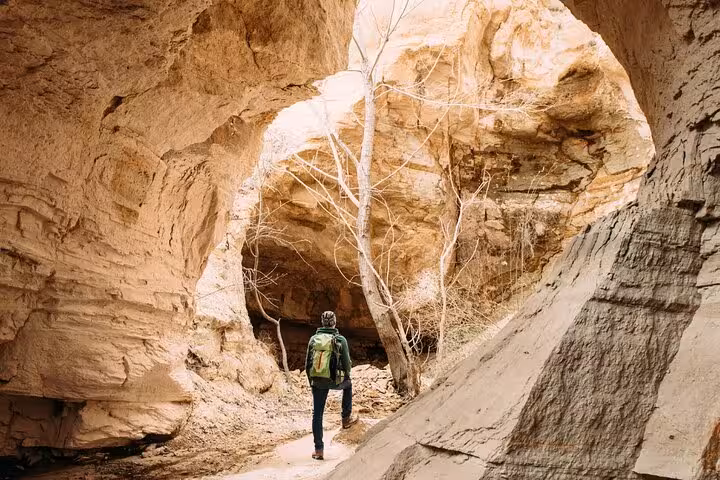 Traveler walking through Cappadocia canyon cave on private day tour from Istanbul by plane, scenic hike