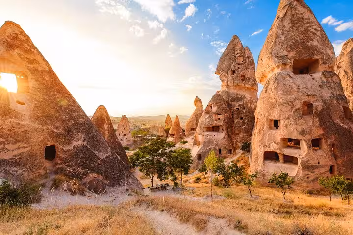Sunlit Cappadocia cave dwellings and fairy chimney rock formations, scenic stop on 8 day Mediterranean tour