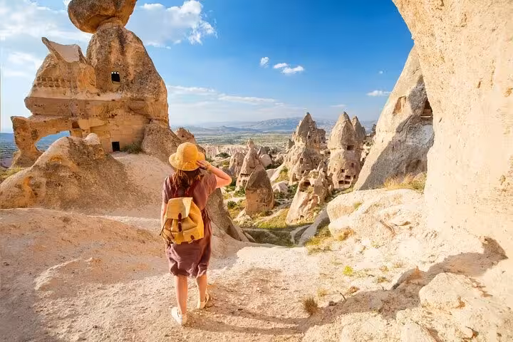 Traveler exploring Cappadocia fairy chimneys viewpoint on private day tour with lunch in Goreme, Turkey