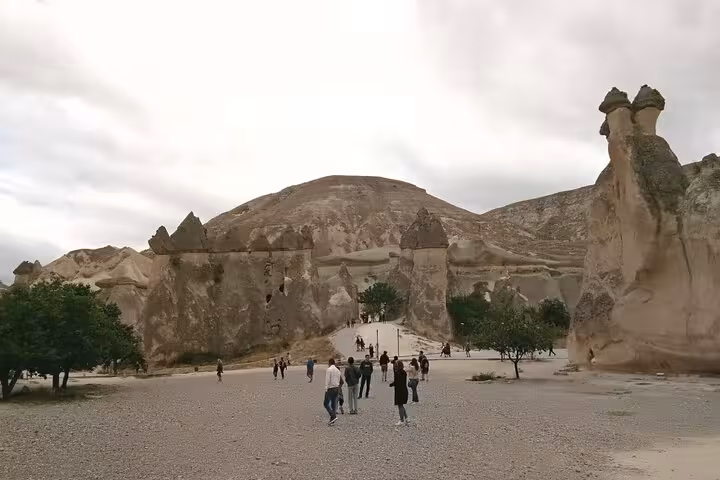 Visitors walk through Cappadocia valley to fairy chimneys on private tour from Istanbul by plane