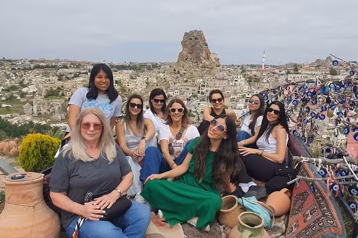 Small group on Cappadocia full-day tour posing at Uchisar viewpoint, panoramic valley scenery and lunch