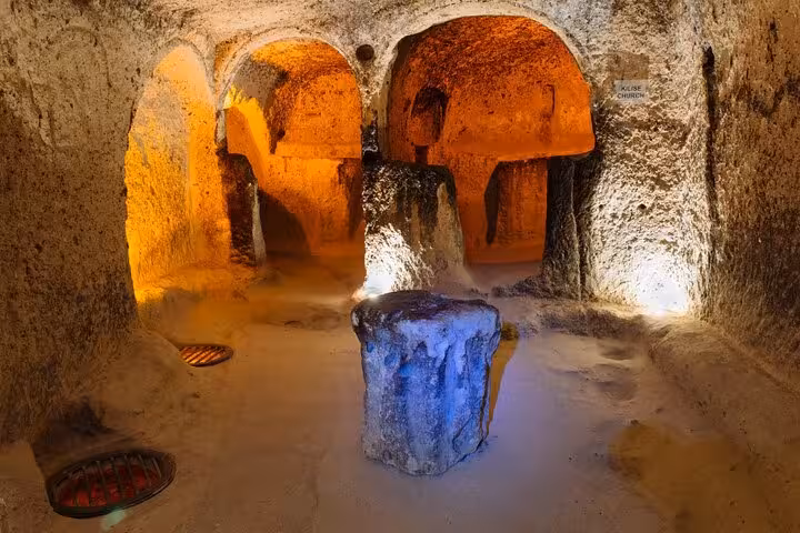 Cappadocia Green Tour stop at an ancient underground city chamber with arched tunnels and stone pillars