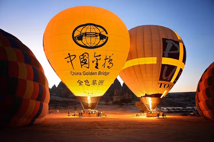 Cappadocia hot air balloons being inflated at dawn, pre-flight glow for a Göreme sunrise balloon tour