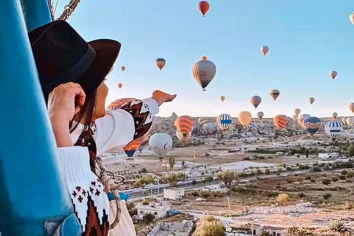 Traveler watches sunrise hot air balloons over Cappadocia on 2-day small group North and South tour