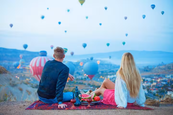 Couple watching Cappadocia hot air balloons at dawn during 2-day Cappadocia Highlights Tour from Istanbul