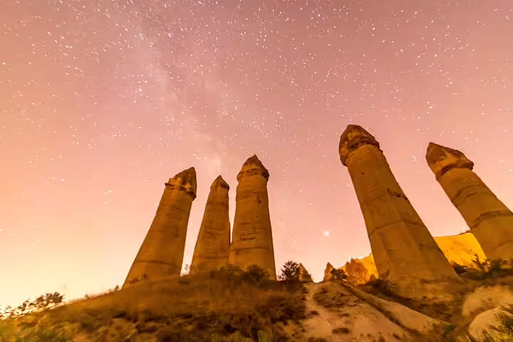 Marvel at Cappadocia's iconic fairy chimneys under a starlit sky on this exclusive private tour experience.