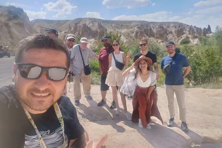 Small group selfie at Cappadocia Red Tour viewpoint with fairy chimneys and valleys behind in Turkey