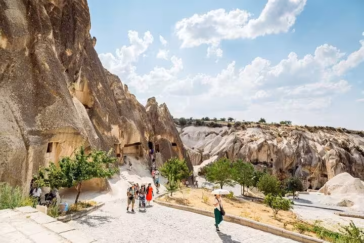 Cappadocia Red Tour stop at Zelve Open Air Museum with cave dwellings, walking paths and visitors, Turkey