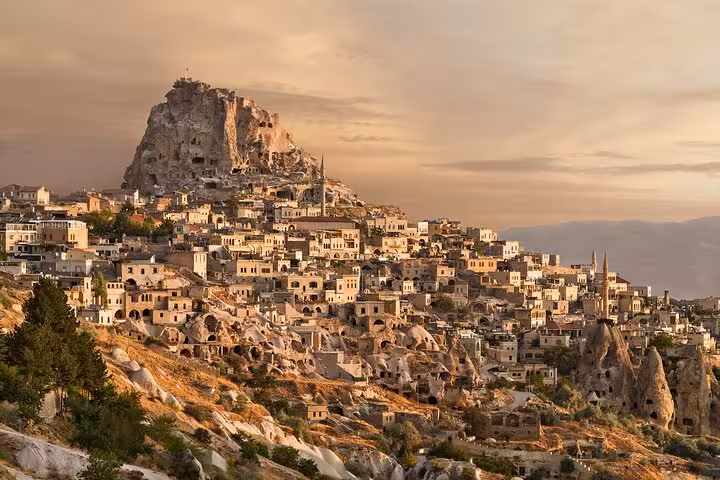 Sunset view of Uchisar Castle and cave houses in Cappadocia on a 2-day tour from Istanbul