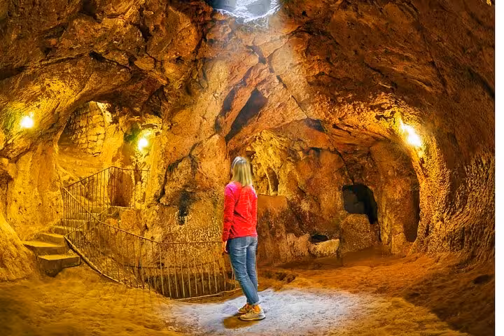 Traveler exploring Cappadocia underground city cave on private tour from Istanbul by plane, guided visit
